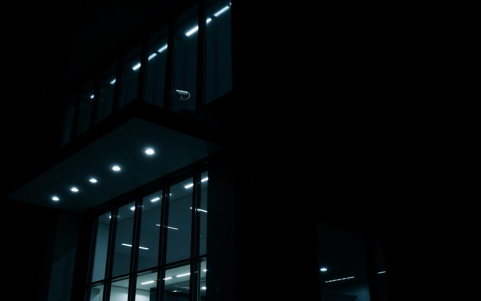 Modernes Bürogebäude bei Nacht mit Überwachungskamera